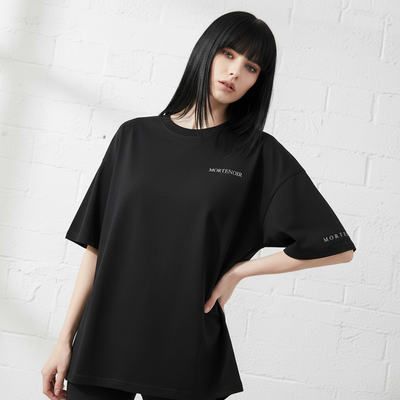 Female model in angled pose with hand on hip wearing black t-shirt