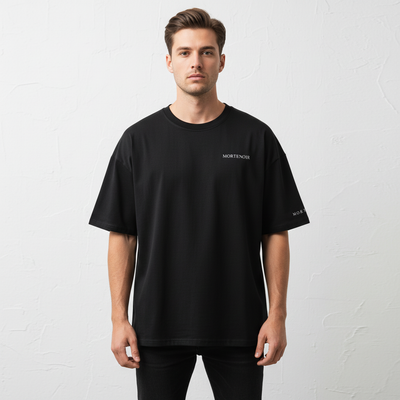 Front view of male model wearing black drop shoulder t-shirt