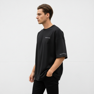Same model in relaxed left side profile stance wearing black t-shirt